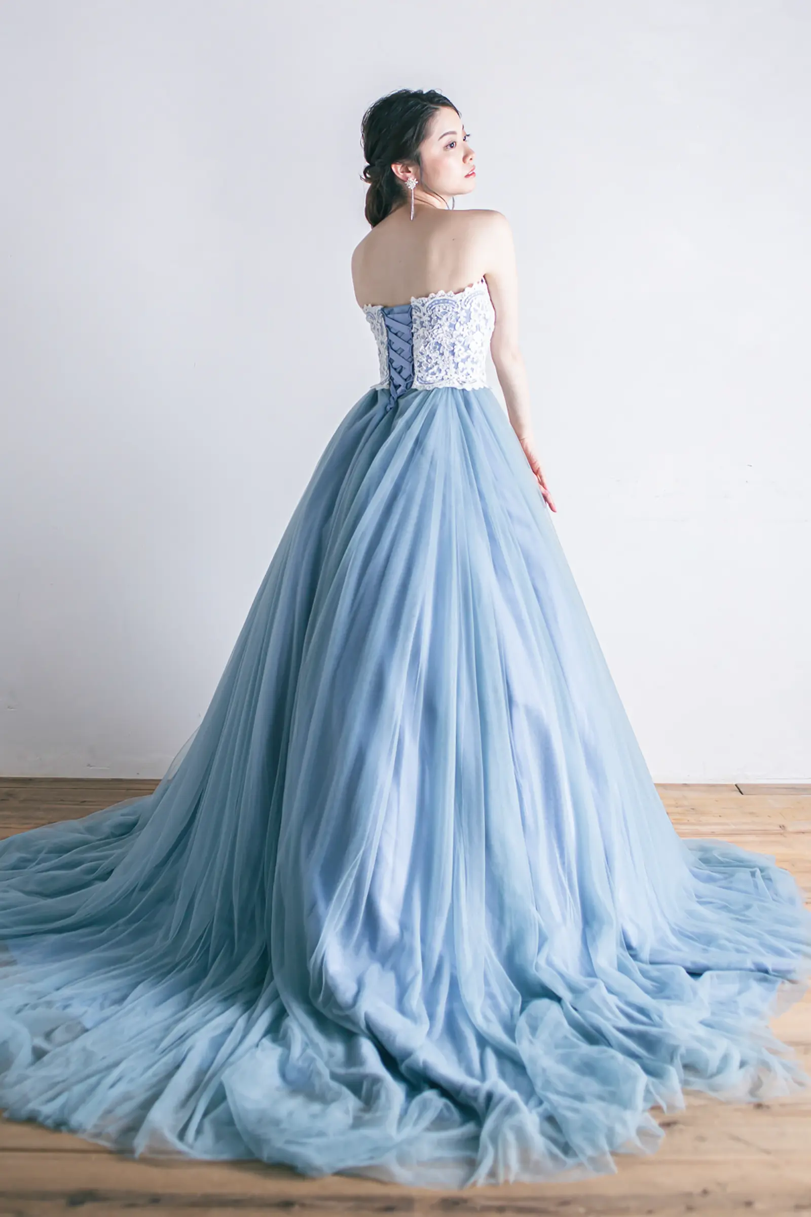 Jellish（ジェリッシュ）の編み上げブルーチュールドレス。サッシュリボンを添えたバックスタイル。