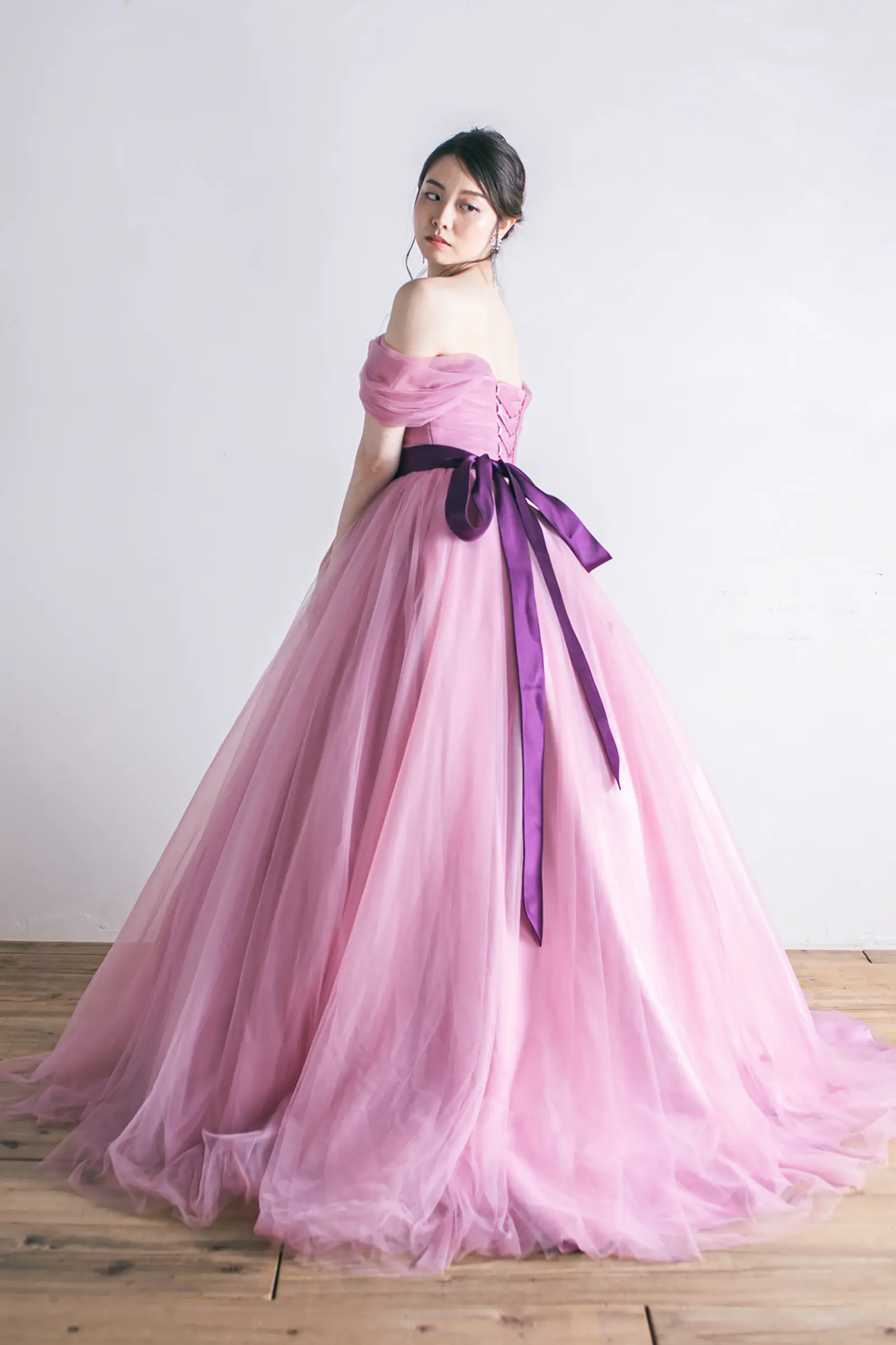Jellish（ジェリッシュ）のアッシュピンクドレス。背中で結んだ濃パープルのリボンが印象的なバックスタイル。