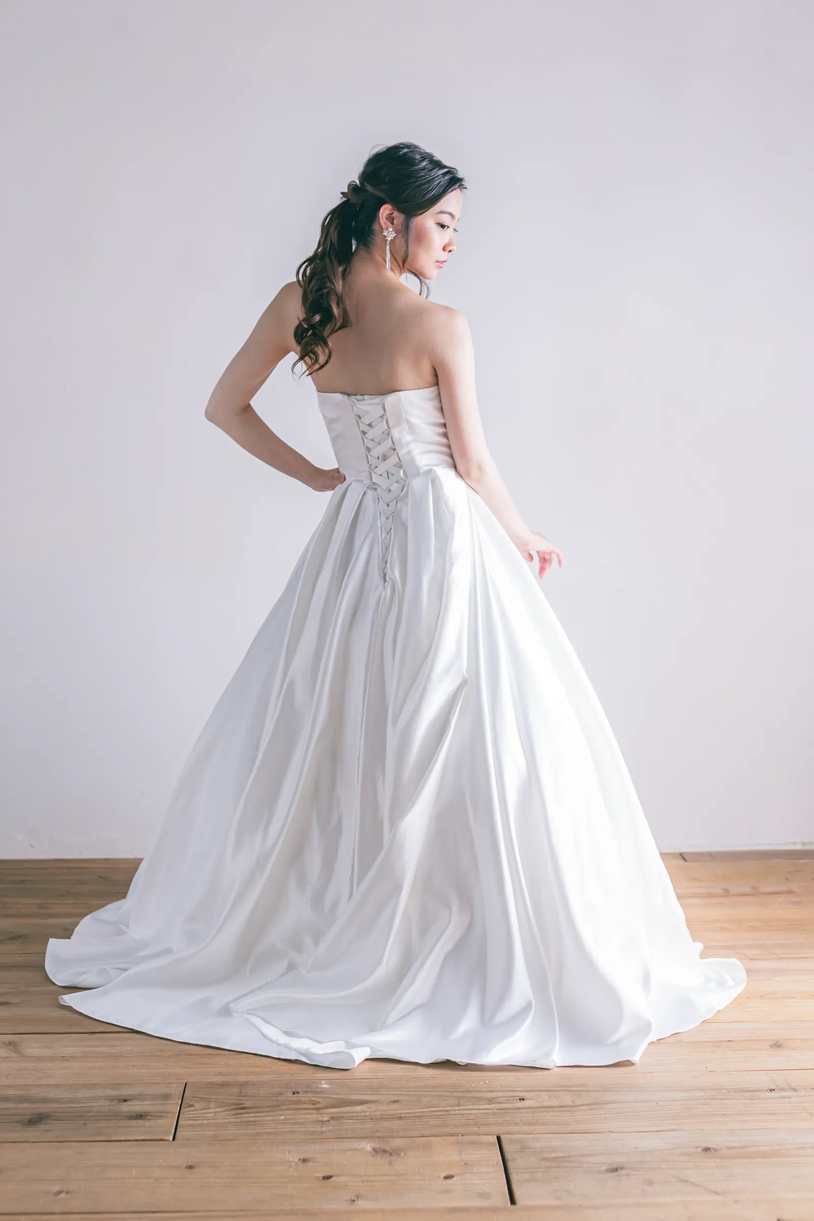 Jellish（ジェリッシュ）の編み上げサテンドレス。チャペルや階段で光沢が美しく映えるバックスタイル。