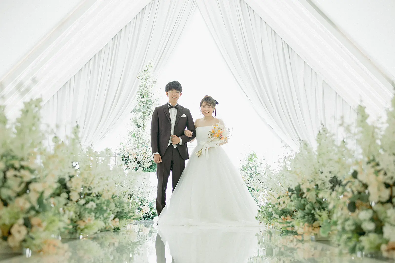 チャペルでウェディングドレスとタキシードを着て挙式と会食を行う新郎新婦