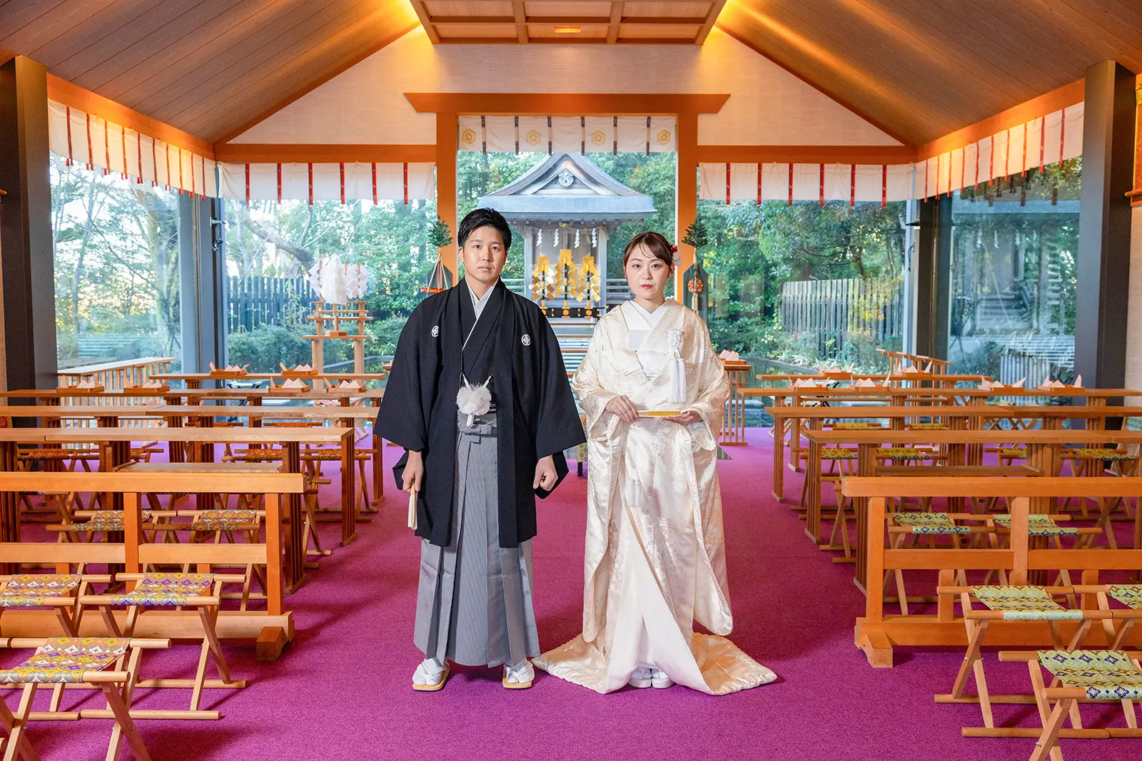 神殿で白無垢と紋付袴を着て神前式と会食を行う新郎新婦