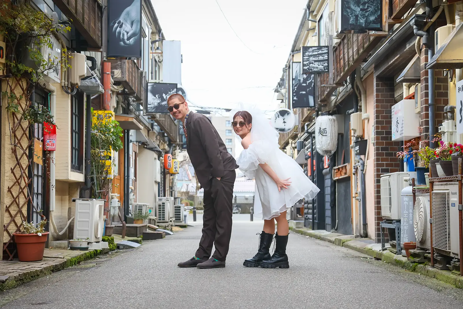 金沢の市街地を背景に、ウェディングドレスとタキシード姿のフォトウェディングを楽しむふたり。フォトジェリッシュによる、洗練されたタウンフォトウェディング。