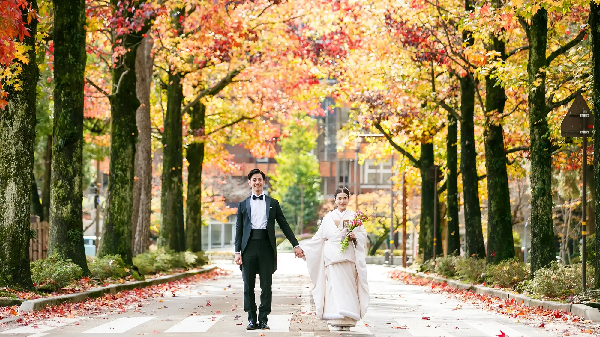 金沢・しいのき迎賓館近くの紅葉並木でのフォトウェディング。タキシードと白無垢を合わせた、常識に囚われない自由なスタイルのロケーションフォト。