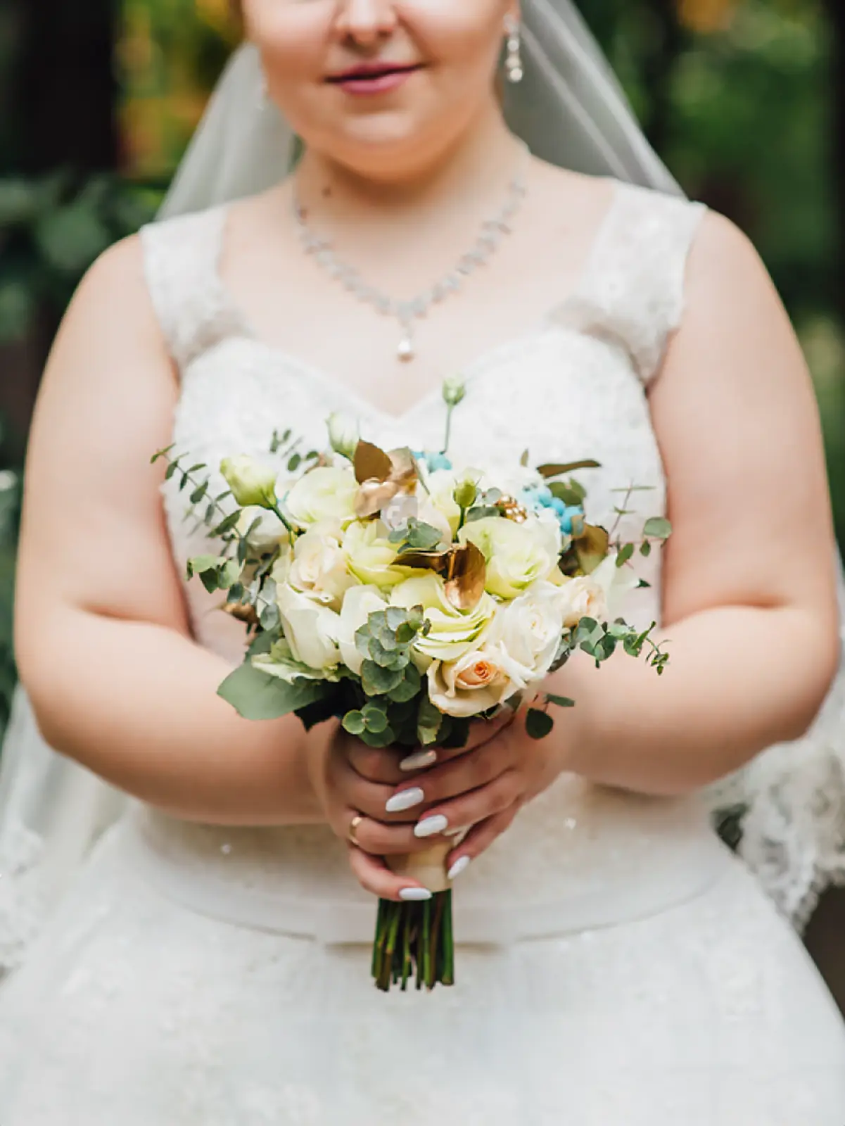 ウェディングドレスを着用し、白とピンクのバラのブーケを手にするプラスサイズのプレ花嫁の姿。フォトジェリッシュが提供する、15号オーバーのプラスサイズのドレス