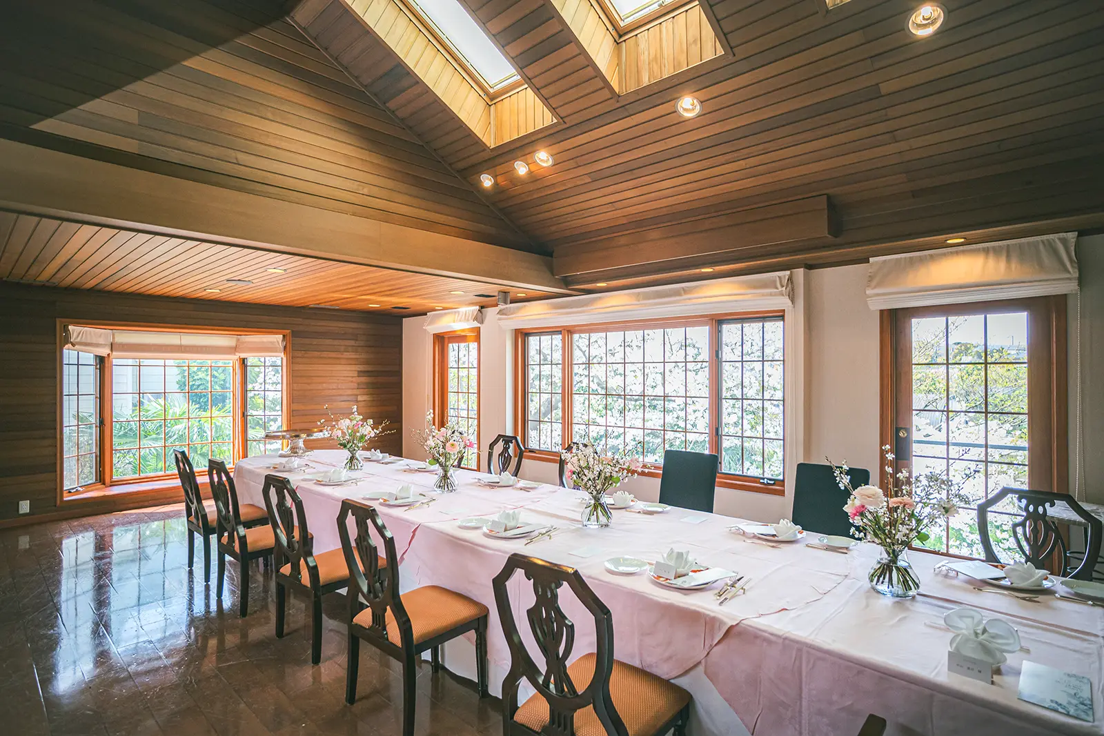 横浜の貸切邸宅・レジデンスにおけるウェディング会食会場。木の温もりを感じる高い天井と柔らかな自然光が差し込み、家族の絆を深めるプライベートな空間を演出している。