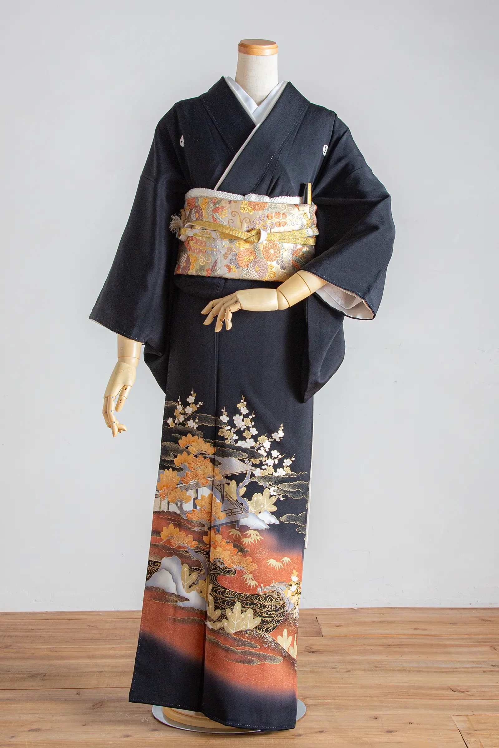 家族婚や結婚式の会食におすすめの、松と梅の景色文様が描かれた黒留袖の全身写真