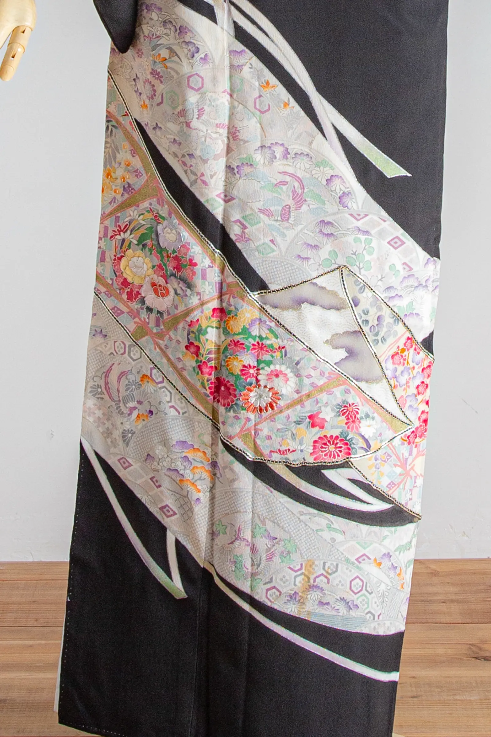 結婚式や家族会食におすすめの黒留袖に描かれた、流水と花文様の柄アップ写真