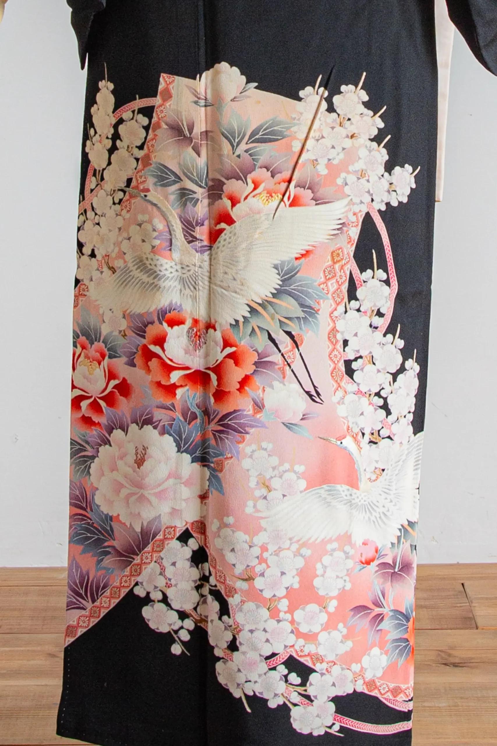 結婚式や家族会食におすすめの黒留袖に描かれた鶴と花文様の柄アップ写真