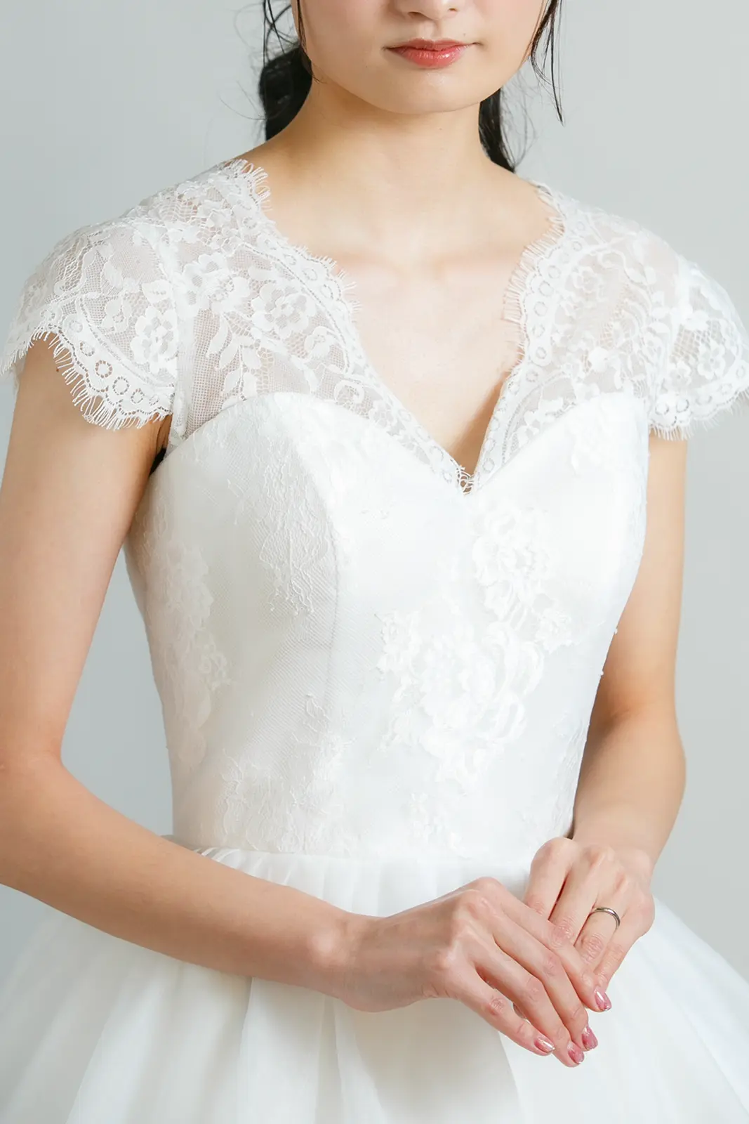 温かみのあるアイボリーのウェディングドレスを着用し、ゴールドの刺繍が施されたドレスを纏う花嫁。イエベ肌の魅力を引き立てる、フォトジェリッシュの上質なドレススタイル。