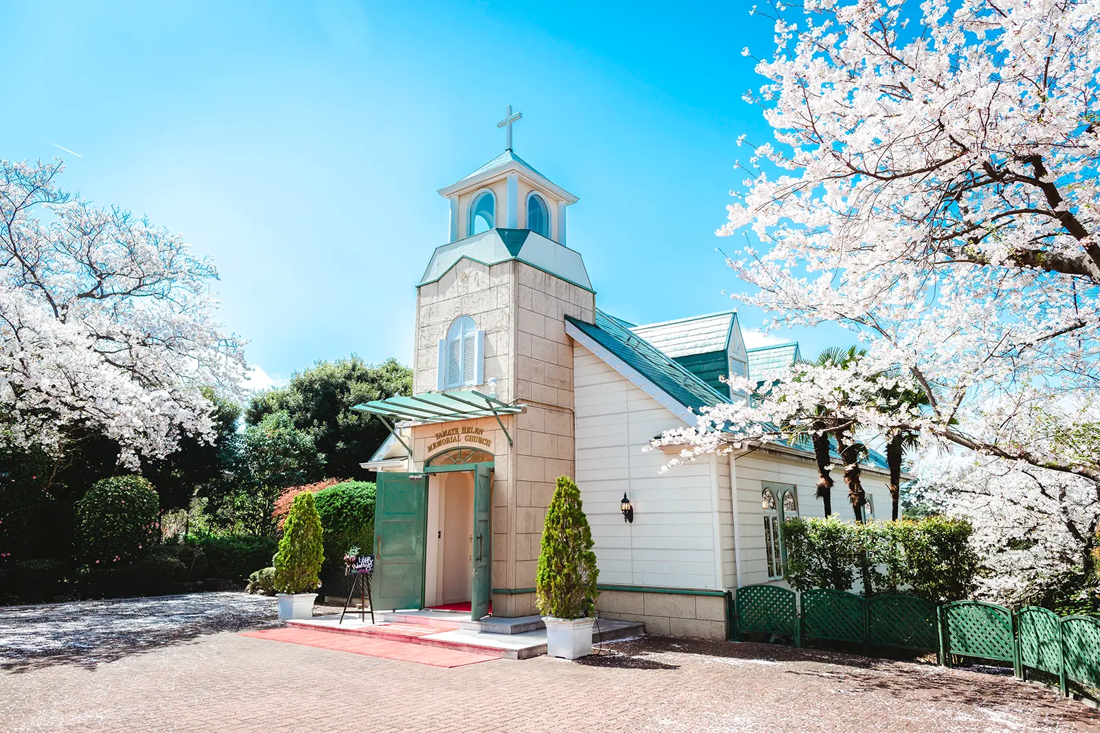 満開の桜に囲まれた横浜の山手ヘレン記念教会の外観。フォトジェリッシュが撮影した、春の穏やかな光に包まれたチャペルフォト。