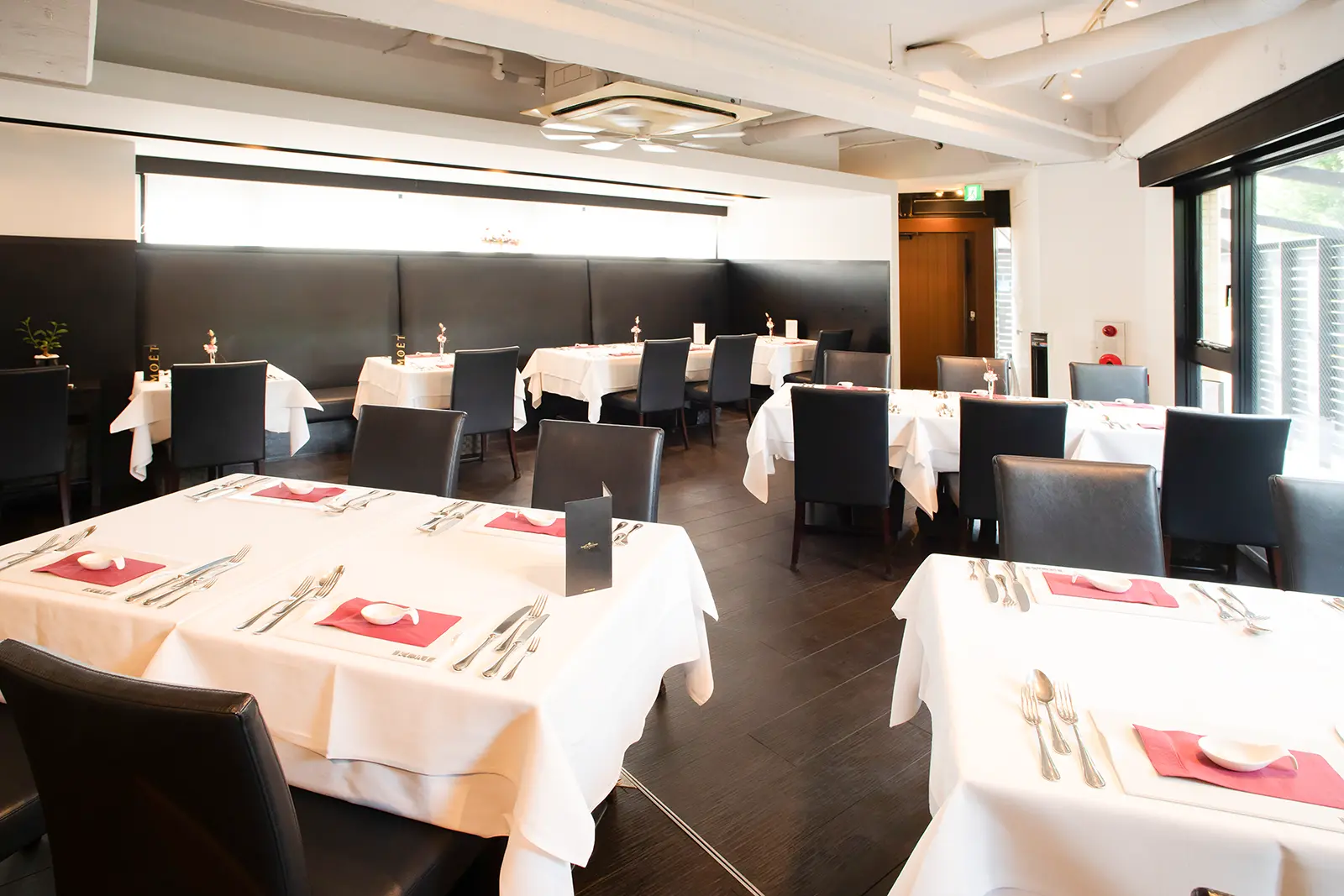 横浜・ジャンティエスコマチの洗練された会食会場。白を基調としたテーブルセッティングとシックなインテリアが、落ち着いたレストランウェディングの雰囲気を演出している。