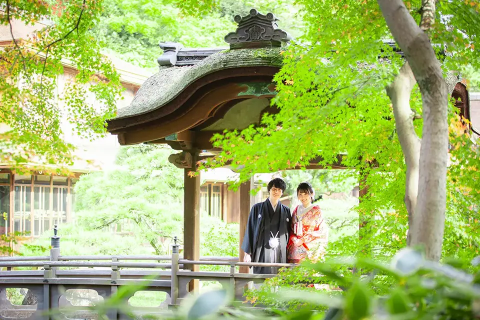 横浜の三溪園で歴史的建造物を背景に和装フォトウェディングを行う新郎新婦
