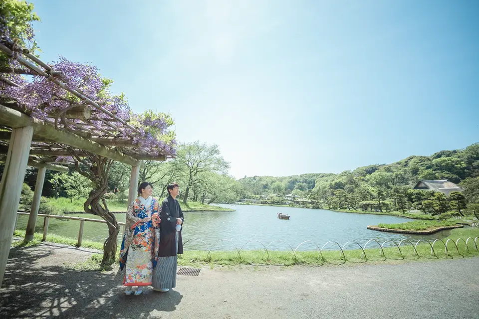 横浜の三溪園で池と庭園を背景に和装フォトウェディングを行う新郎新婦