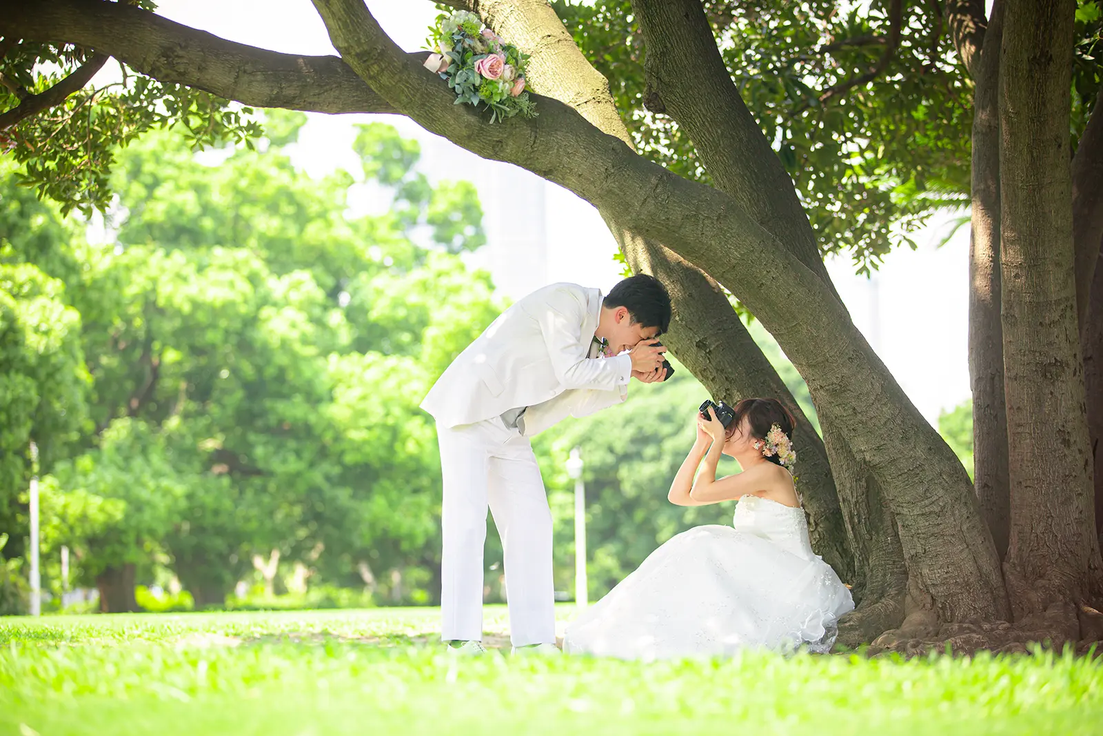 横浜・山下公園の海岸沿いで、氷川丸を背景に見つめ合うウェディングドレスとタキシード姿のカップル。フォトジェリッシュによる爽やかなロケーションフォト。